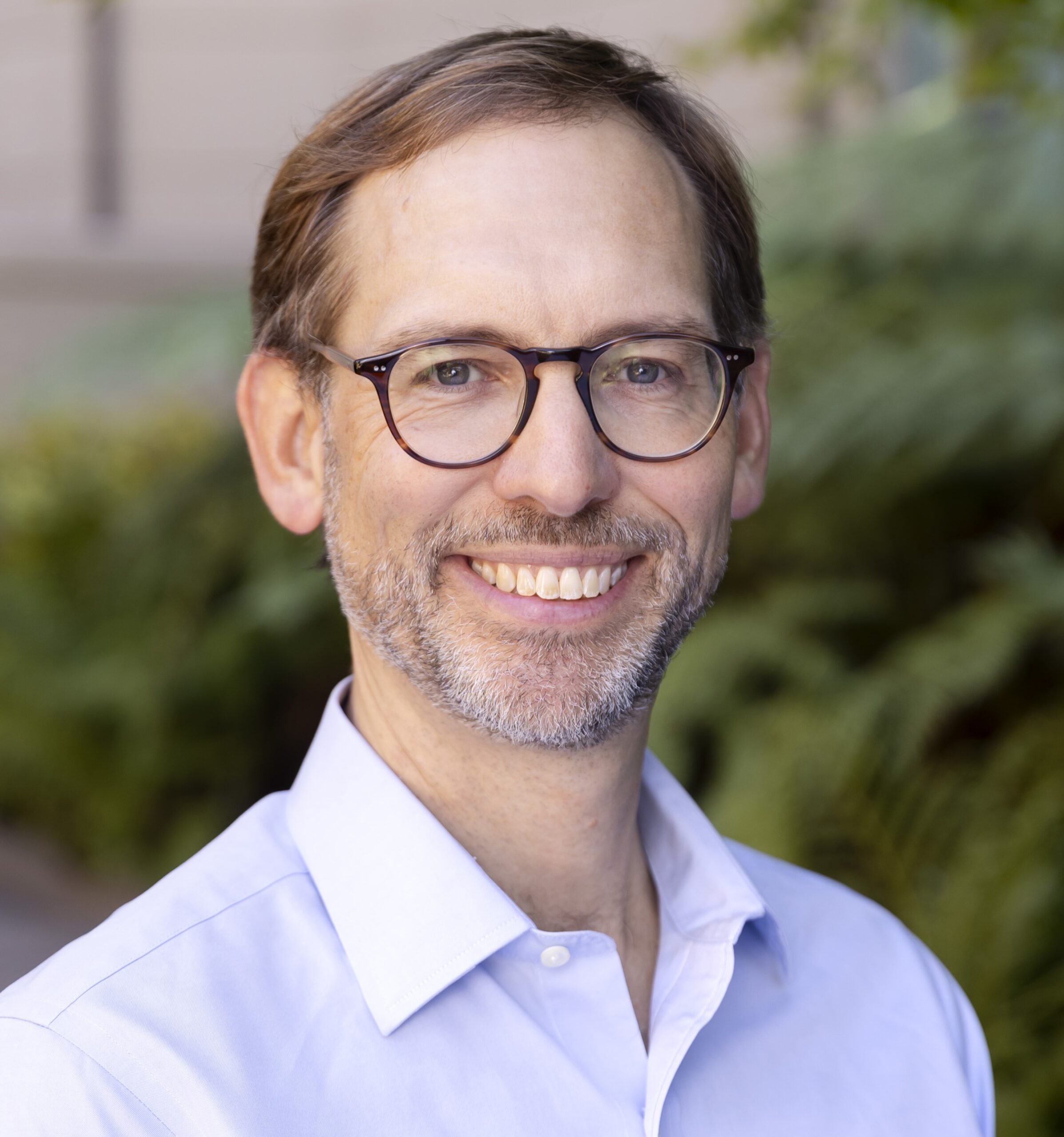 headshot of Andrew Campbell against a leafy background