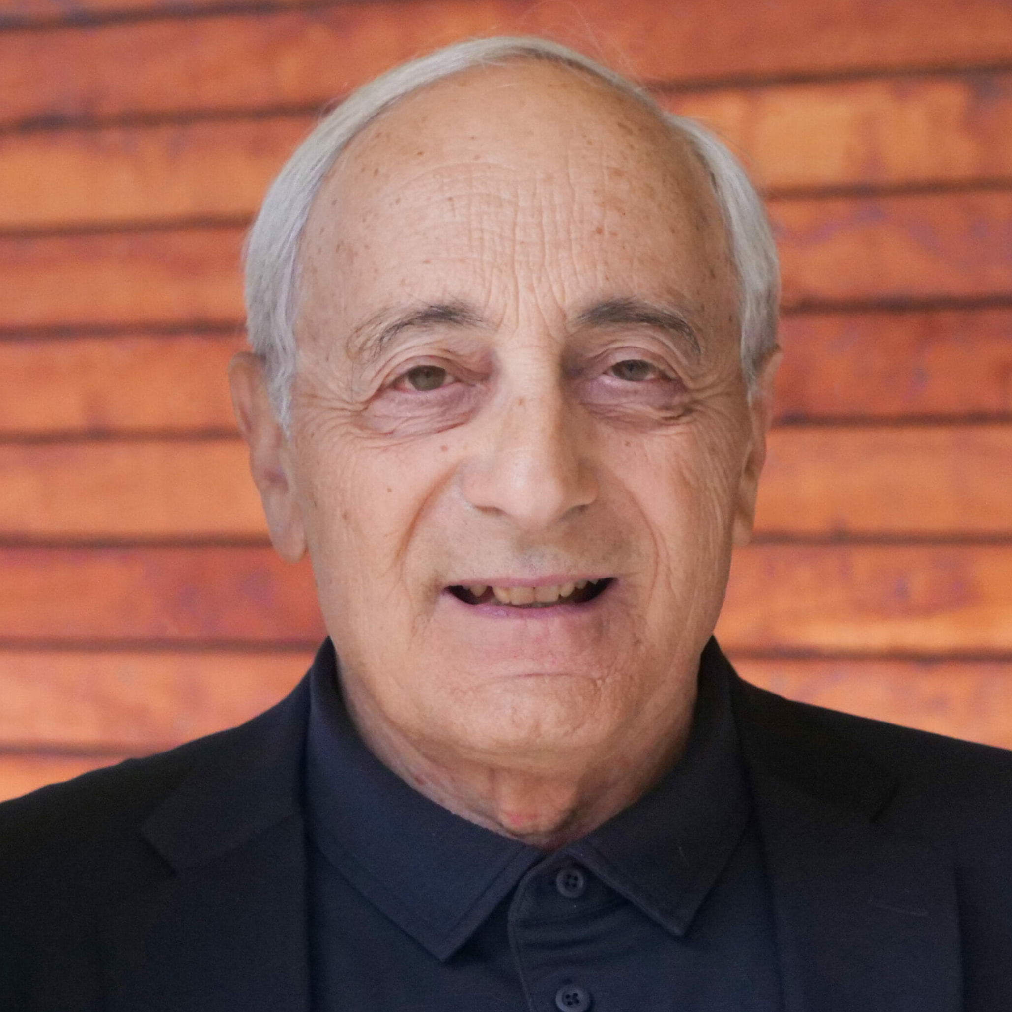 headshot of Michael Reich against the backdrop of a brick wall